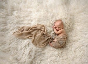newborn on white flokati rug