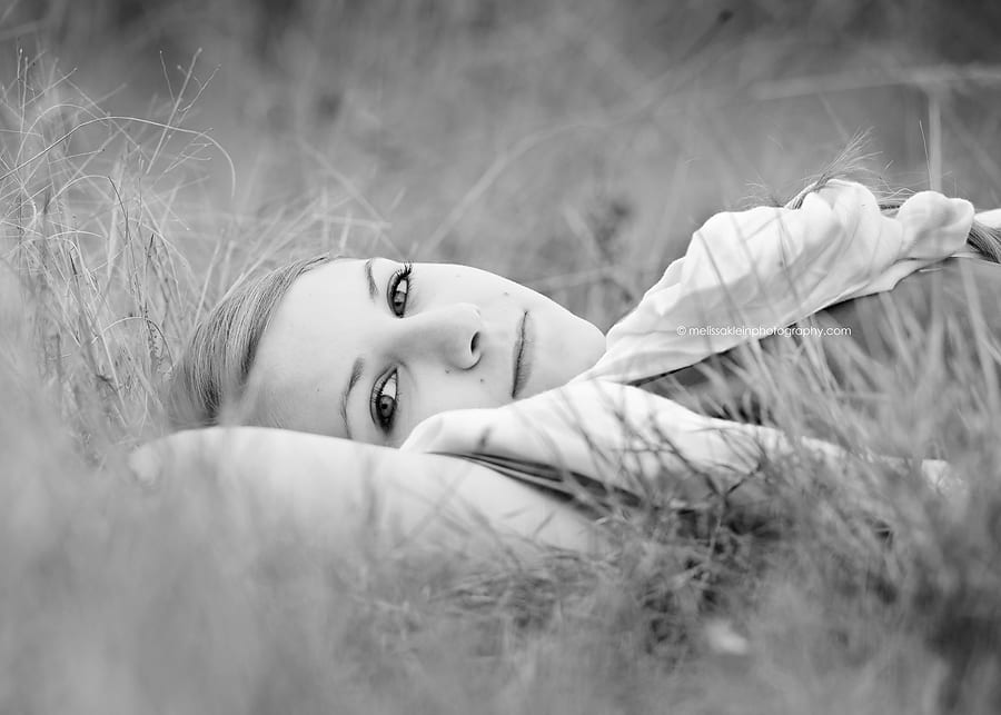 girl lying in tall grass