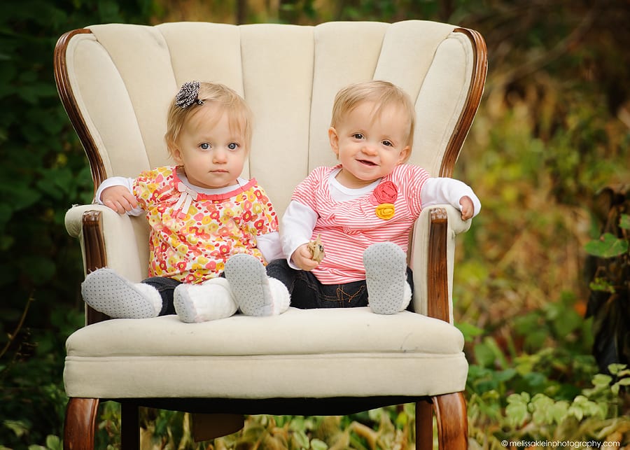 1 year old twin sisters sitting in chair