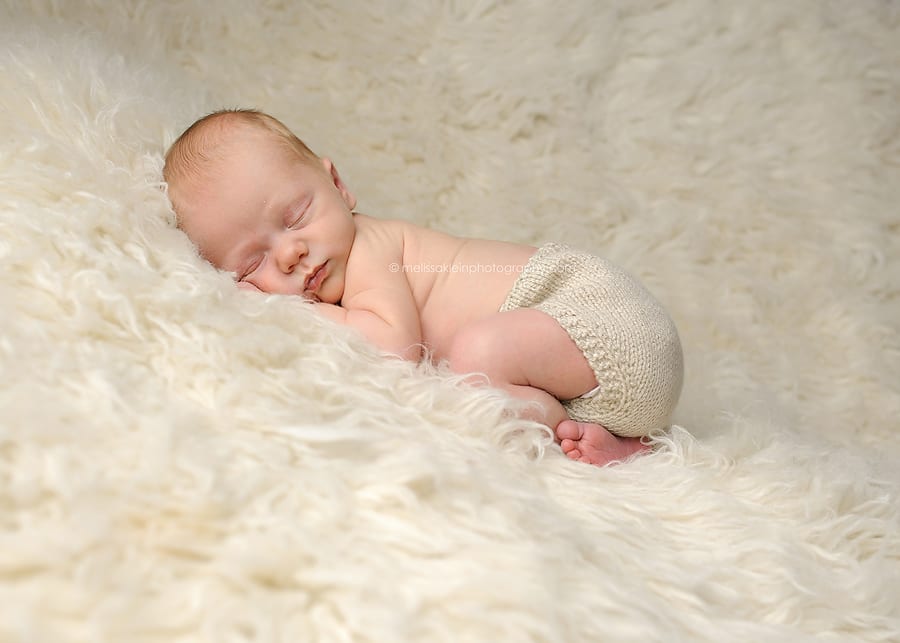 newborn on white fluffy rug