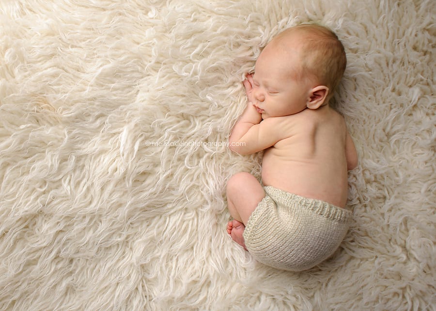 newborn baby on white fluffy rug