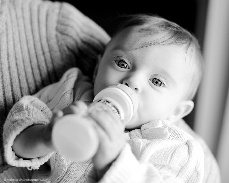 baby holding bottle 