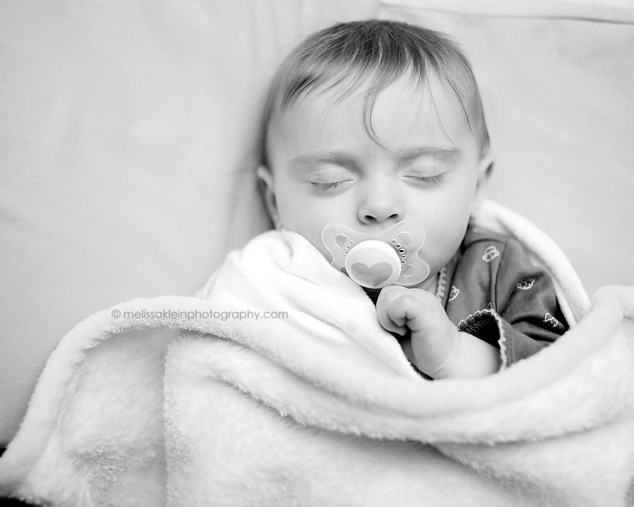 baby sleeping in crib with pacifier