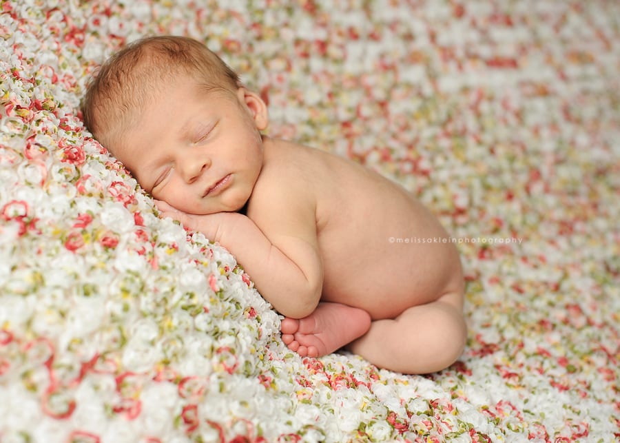 newborn girl on flower fabric