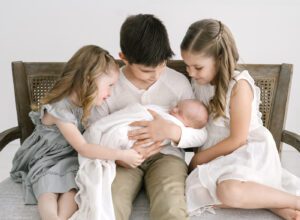 newborn baby with three older siblings