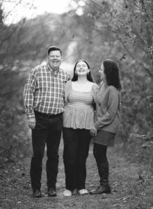 black and white outdoor photos of parents with teenage girl laughing