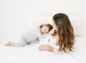 maternity photo of mom on bed with toddler