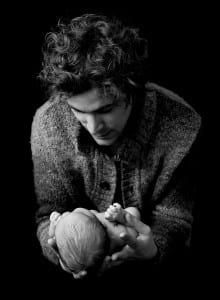 black and white photo of dad holding newborn baby