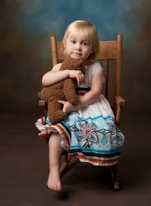 girl in rocking chair with teddy bear