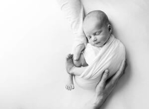 newborn photo with parents hands