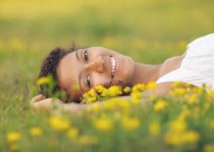 girl laying in field of yellow flowers