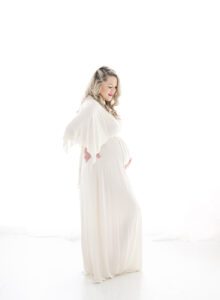 angelic backlit maternity photo of mom in white dress
