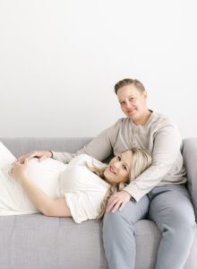 same sex maternity photos of couple on couch in studio