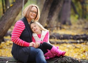 mom and daughter sitting on a log