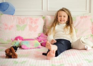 girl on bed with toys