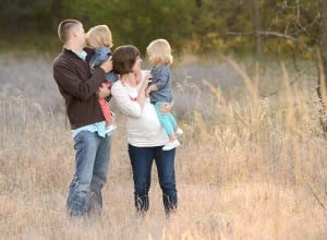 family maternity photos in a field