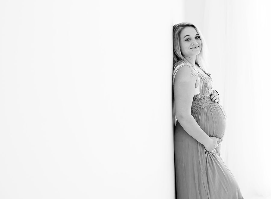 Pregnant mom poses for maternity photos wearing slip dress from Free People