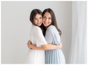 mom with teenage daughter in white studio