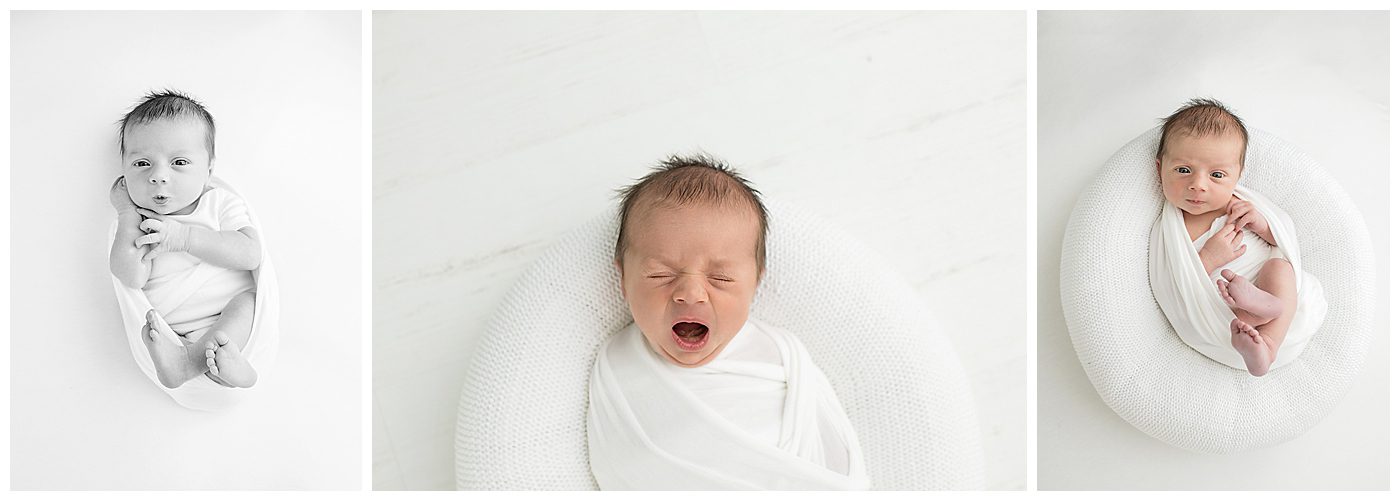 newborn baby in white onesie on white blanket