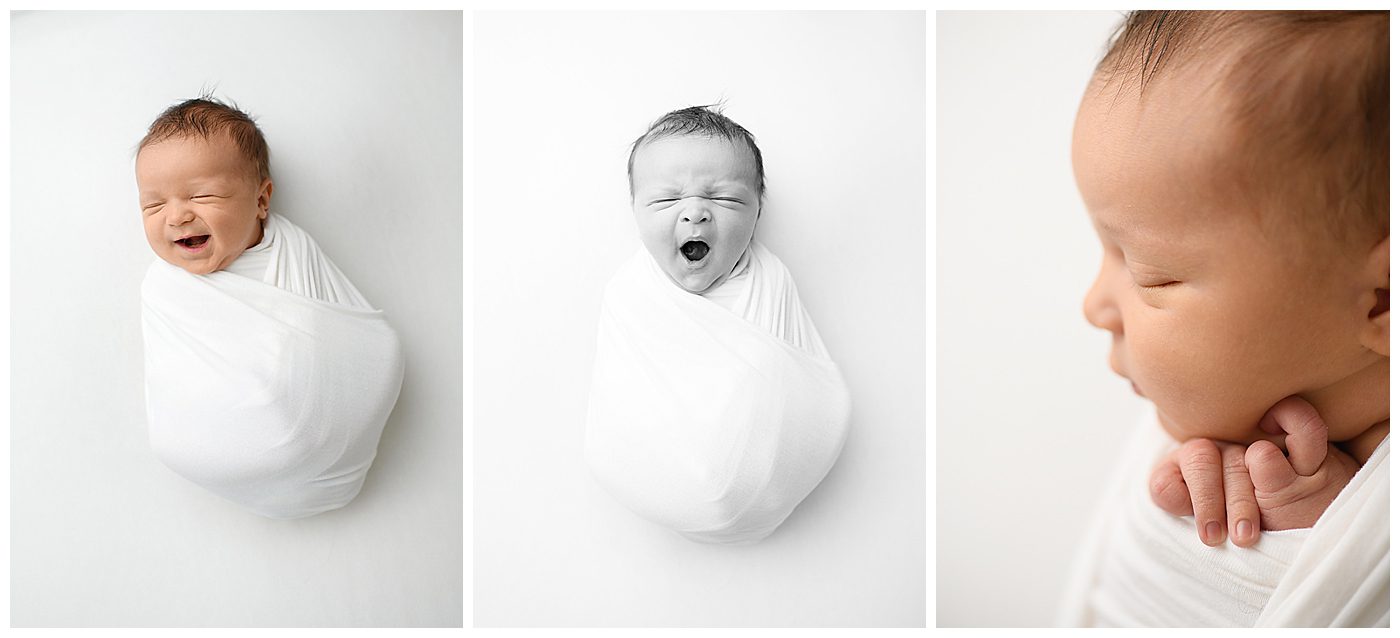 Newborn baby on white blanket, yawning and smiling