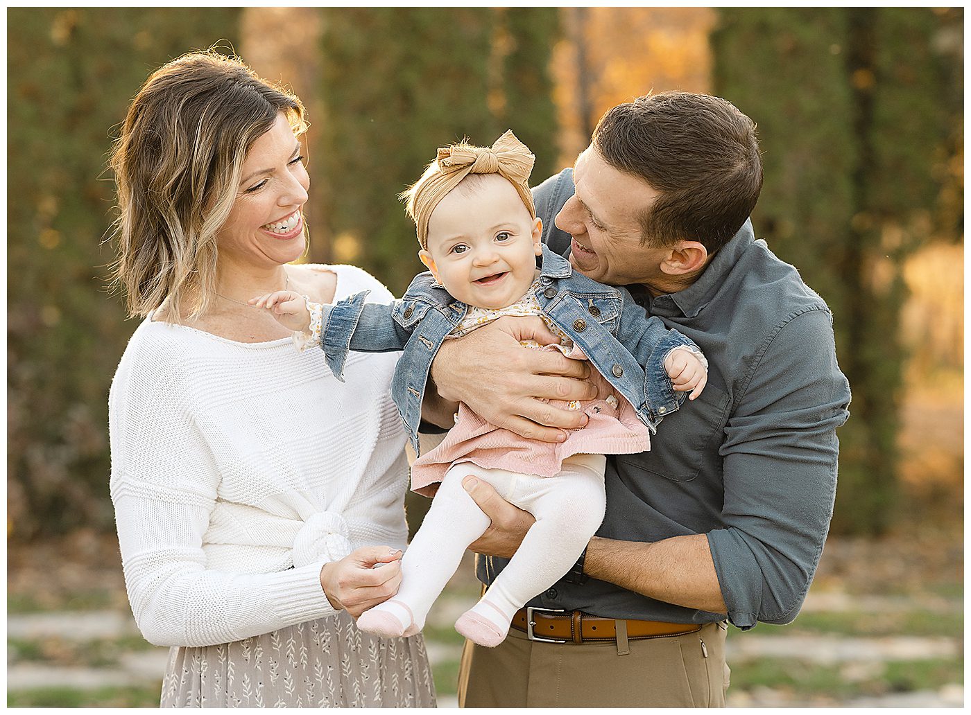 10 month old baby girl being held by mom and dad during fall family photos in Plymouth MN