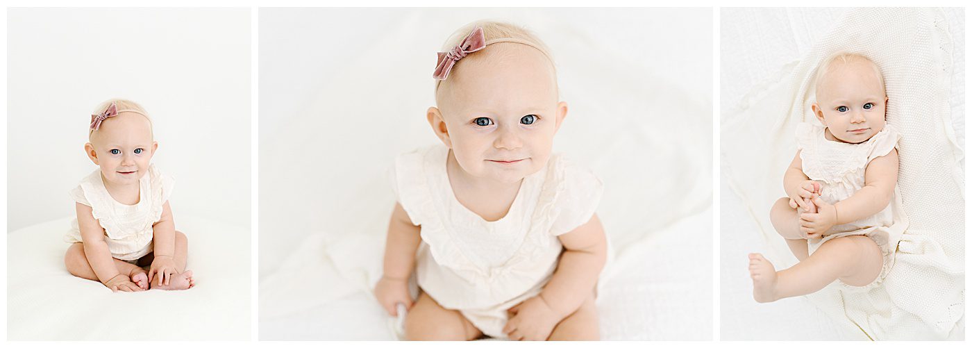 Six month photos of baby girl sitting up on white bed