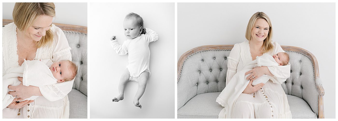 mom in white dress holding newborn baby girl on grey couch
