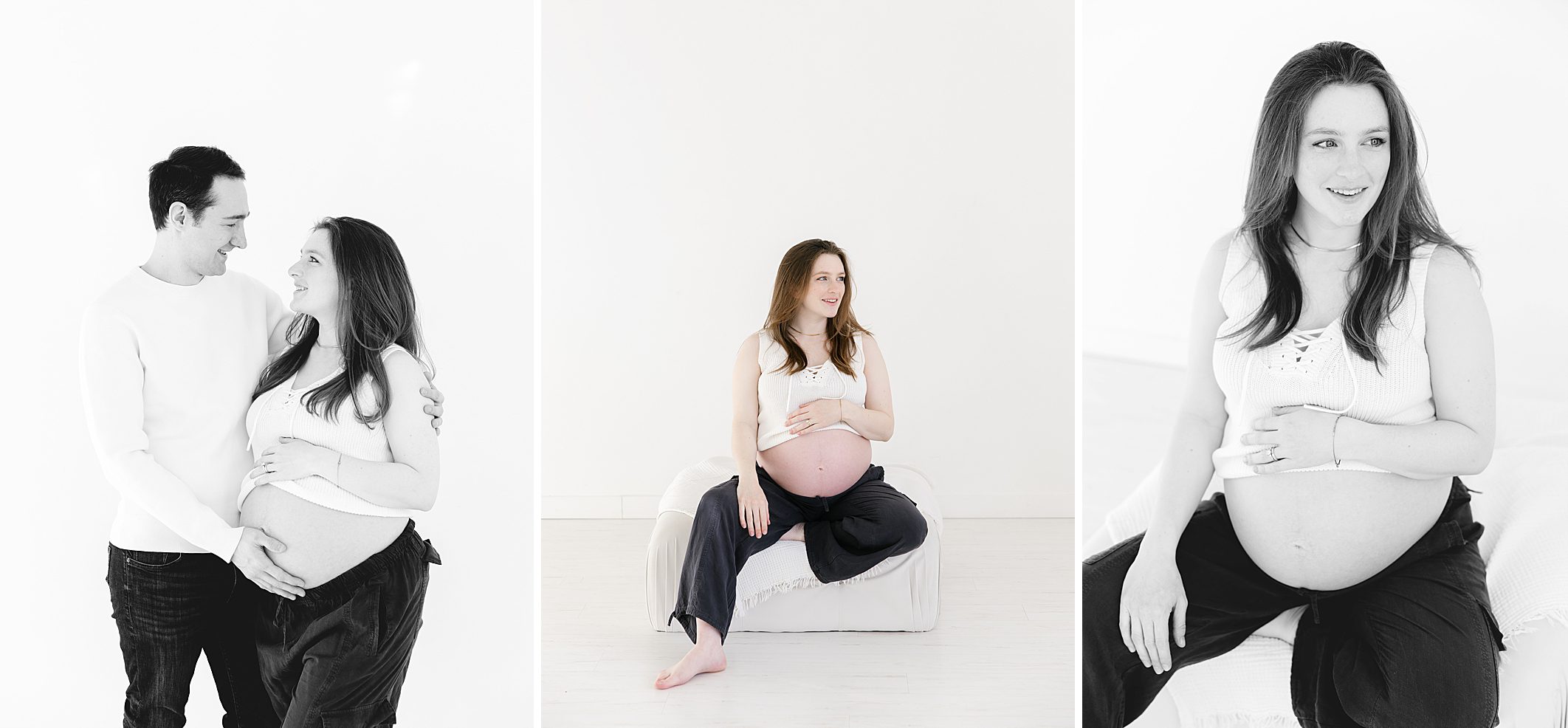 pregnant mom with dark pants and white crop top sitting on white ottoman