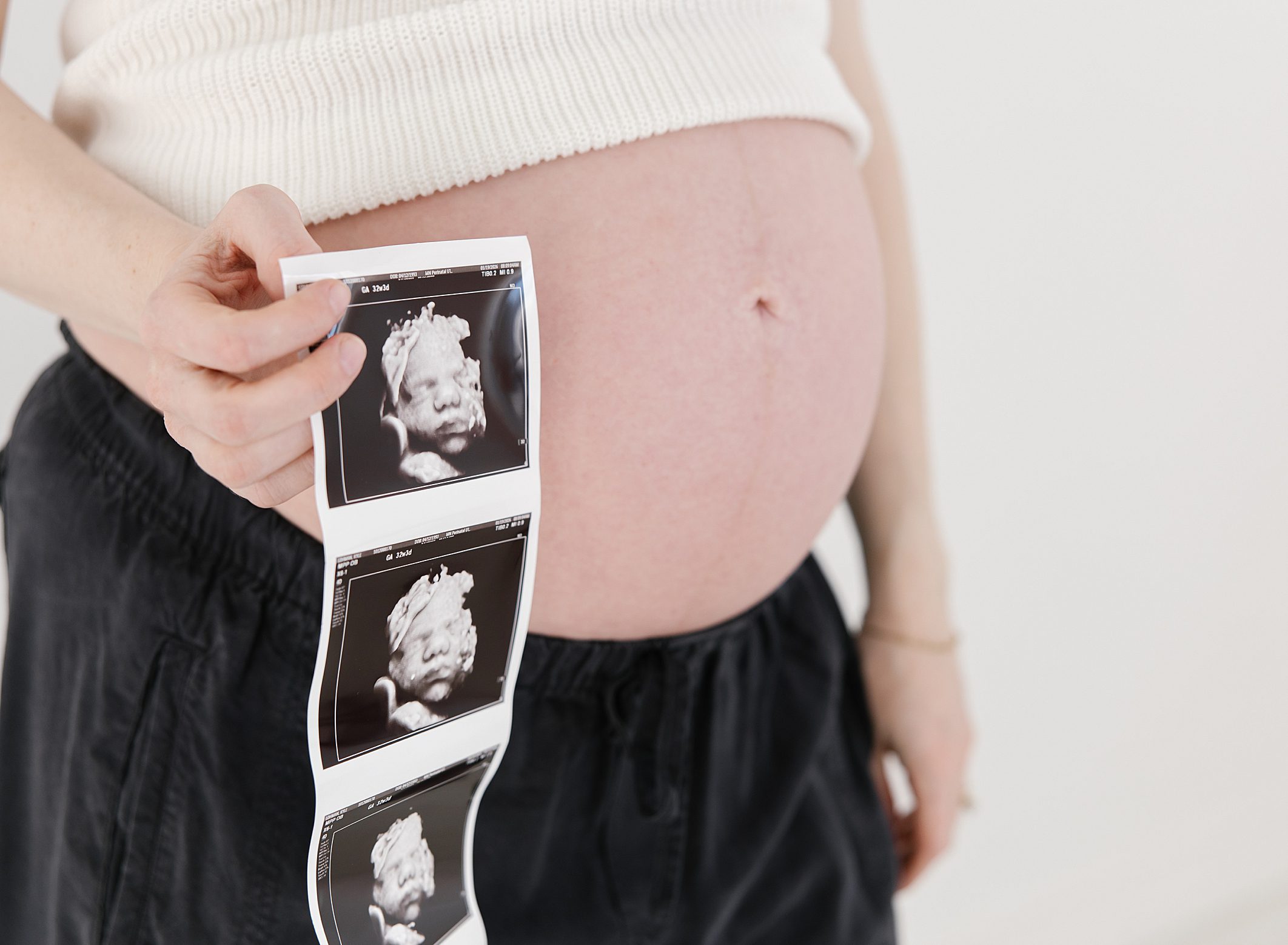 close up photo of pregnant belly and ultrasound photos