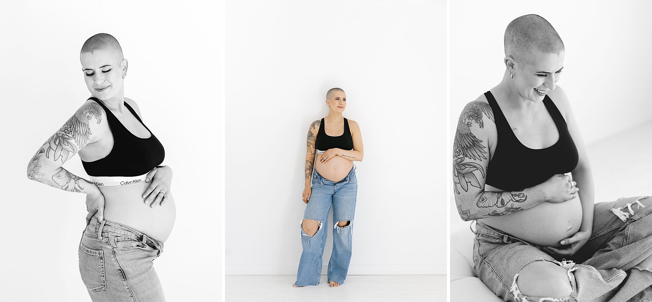 maternity photos of mom with cancer in jeans and black sports bra holding belly along white wall