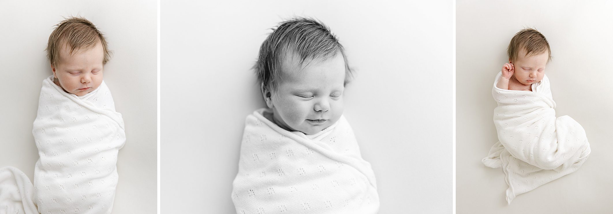 black and white photos of baby girl smiling while swaddled on a white blanket